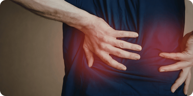 Man Holding Lower Back In Pain | Spinal and Postural Health | EPC Wheelchairs UK